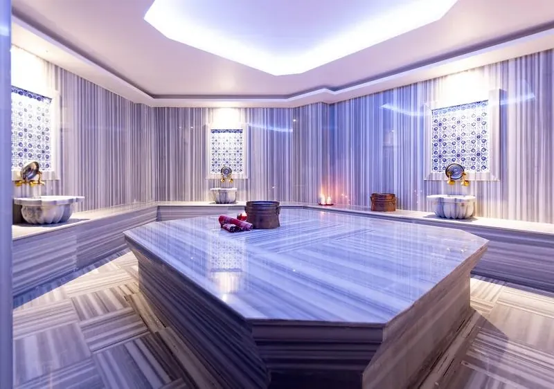 Marble heated stone under a lit ceiling in the partner hamam